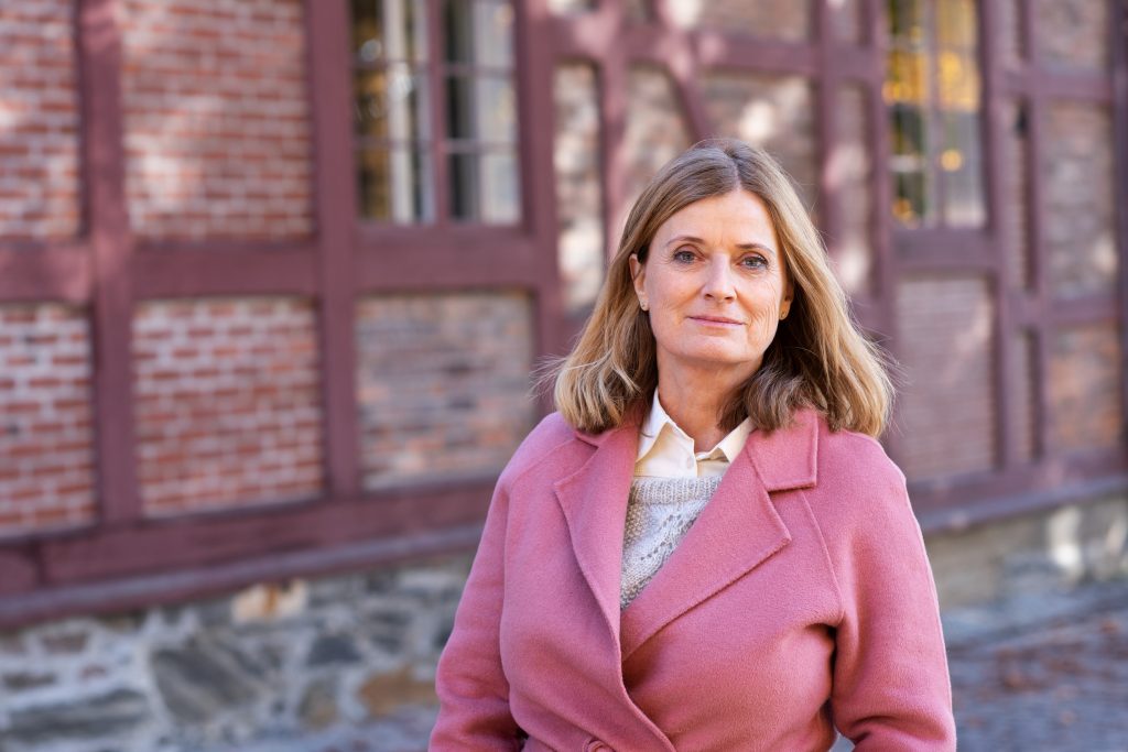 Sivilombud Hanne Harlem rosa kåpe foran bygning på Akershus festning Foto: Mona Ødegård, Sivilombudet