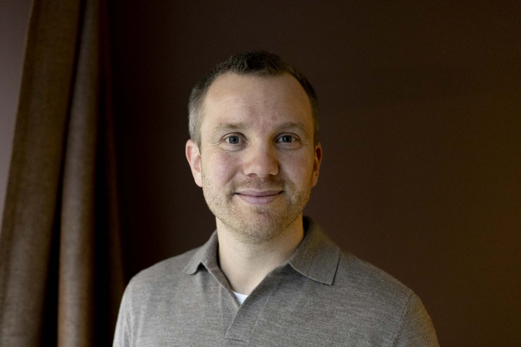 Portrettfoto mann med kort hår i grå skjorte